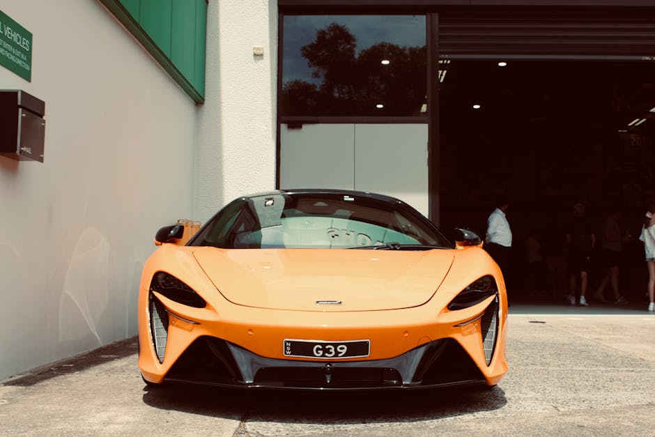 Stunning orange sports car showcased at showroom entry, capturing luxury and elegance.