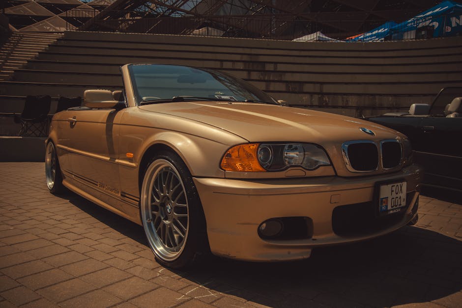 A luxurious gold convertible car parked outdoors.