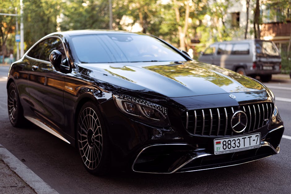 Elegant black luxury car parked on urban road.